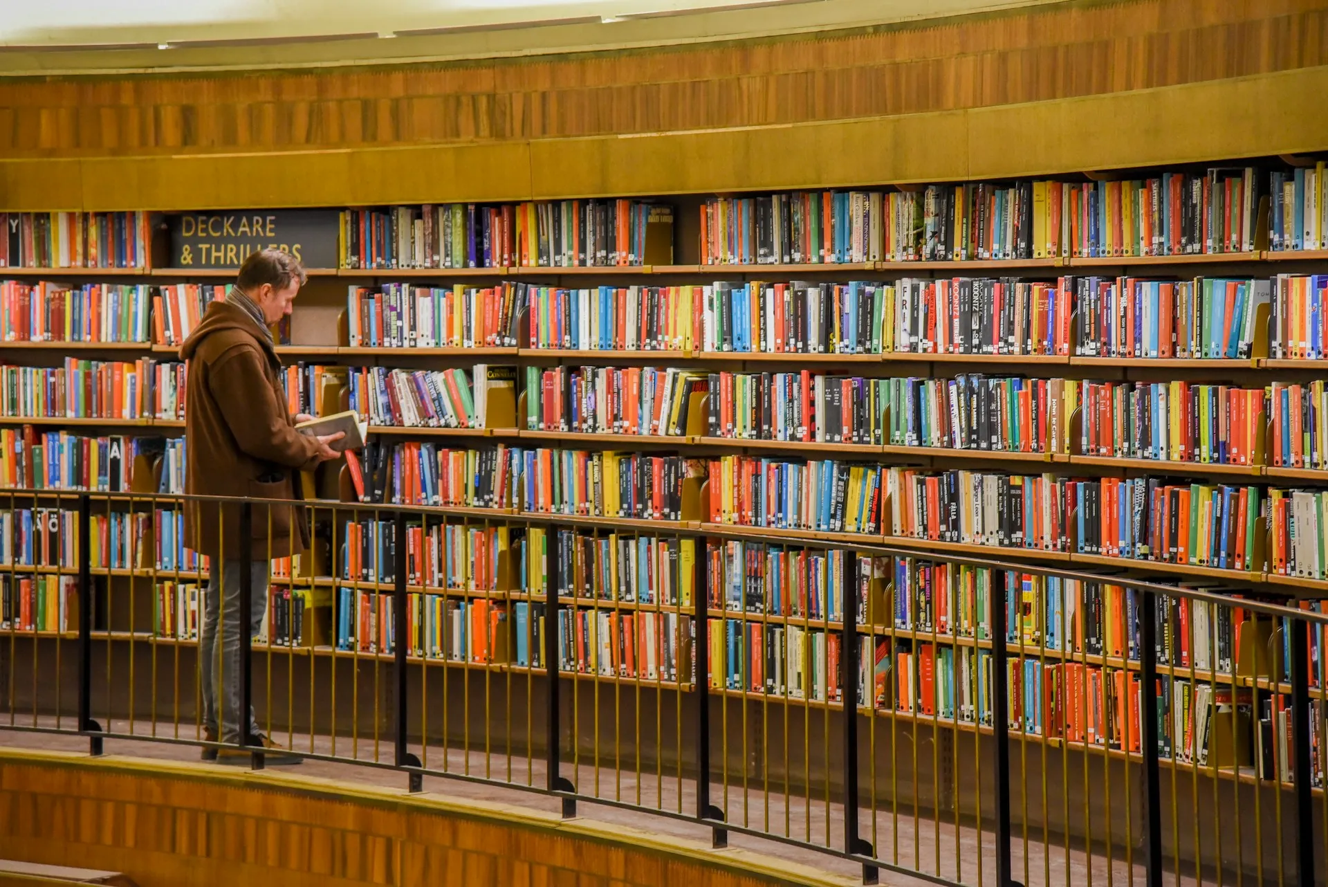 Man reading a book in a library.